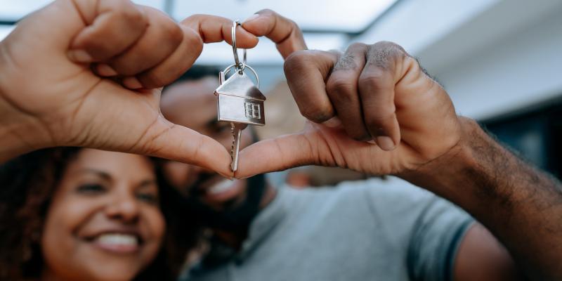 woman smiling holding a key with a house keychain